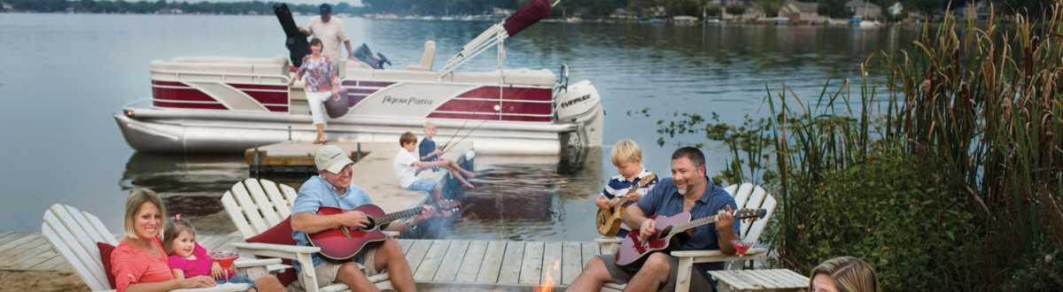 A family gathering filled with merry antics and taking in place next to a boat dock with a pontoon stationed at it.